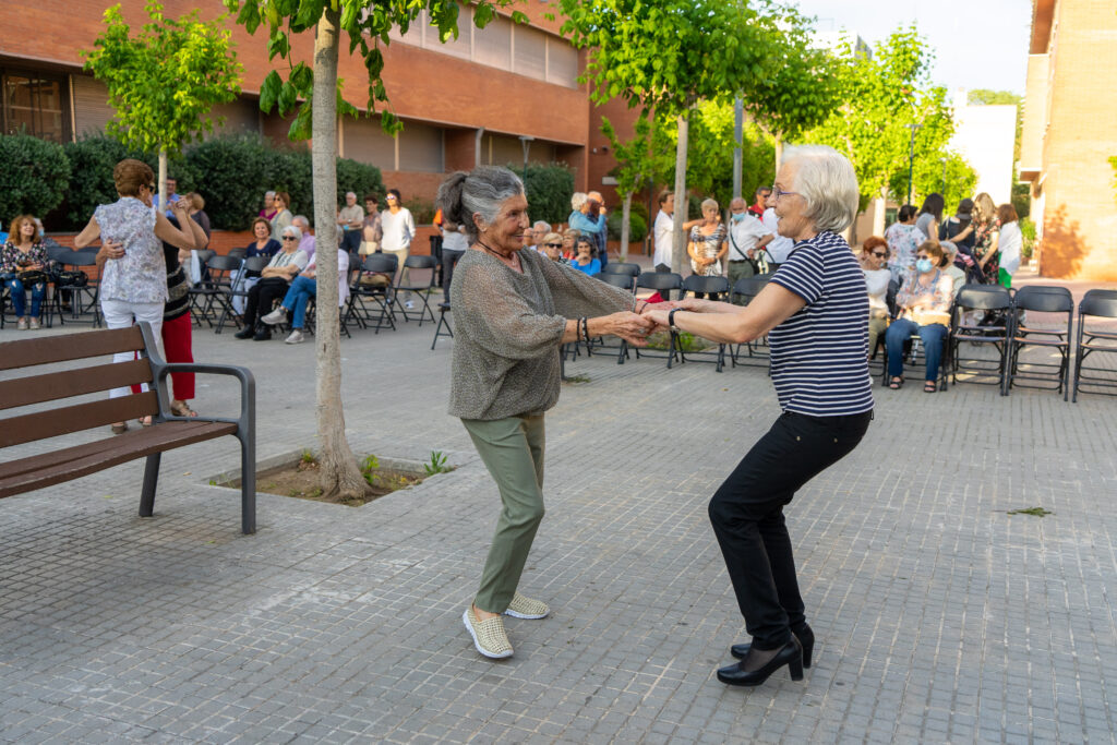 Dues dones grans ballen al carrer agafades de la mà