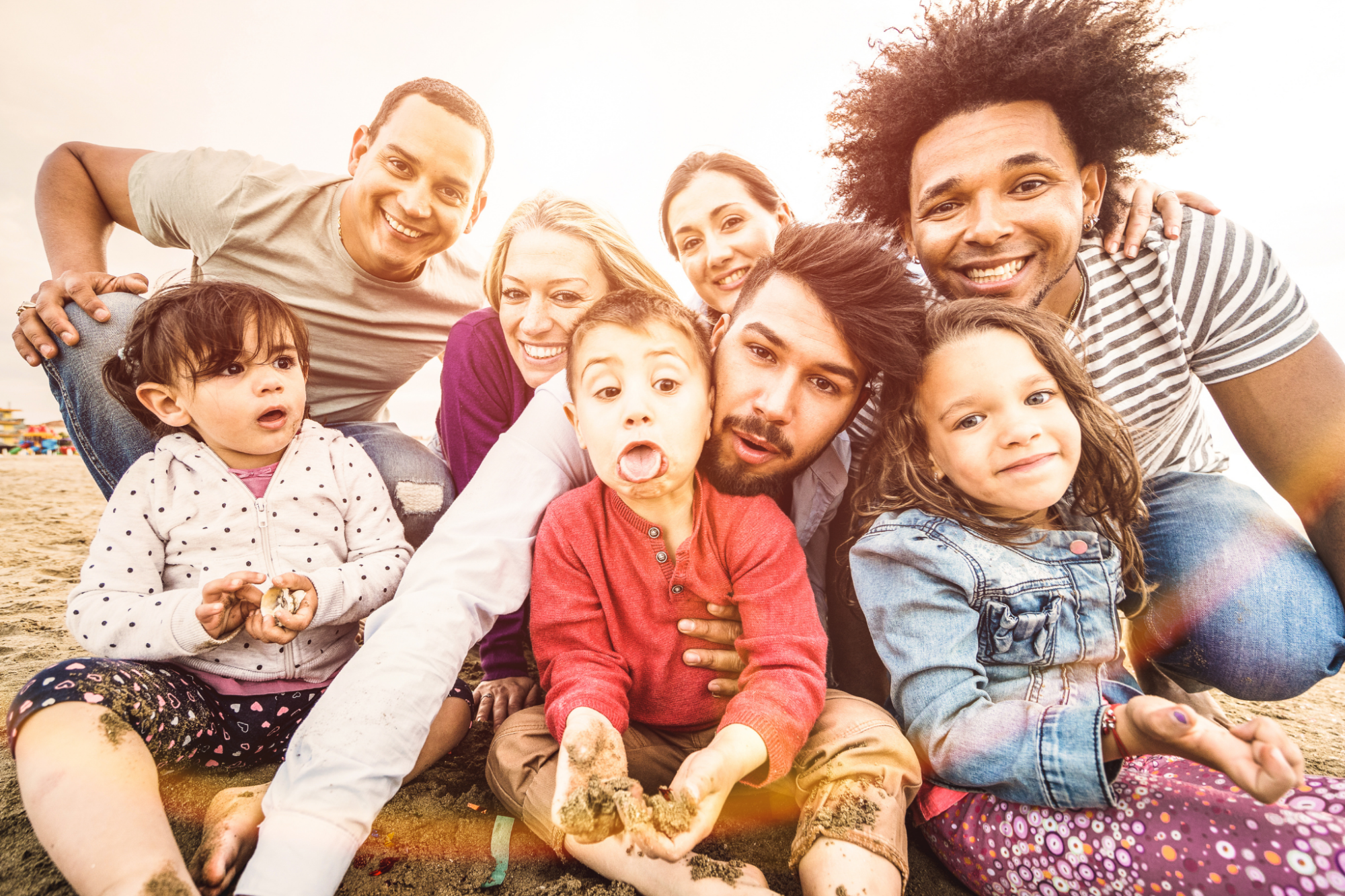 Persones adultes i infants somrient representant la diversitat familiar