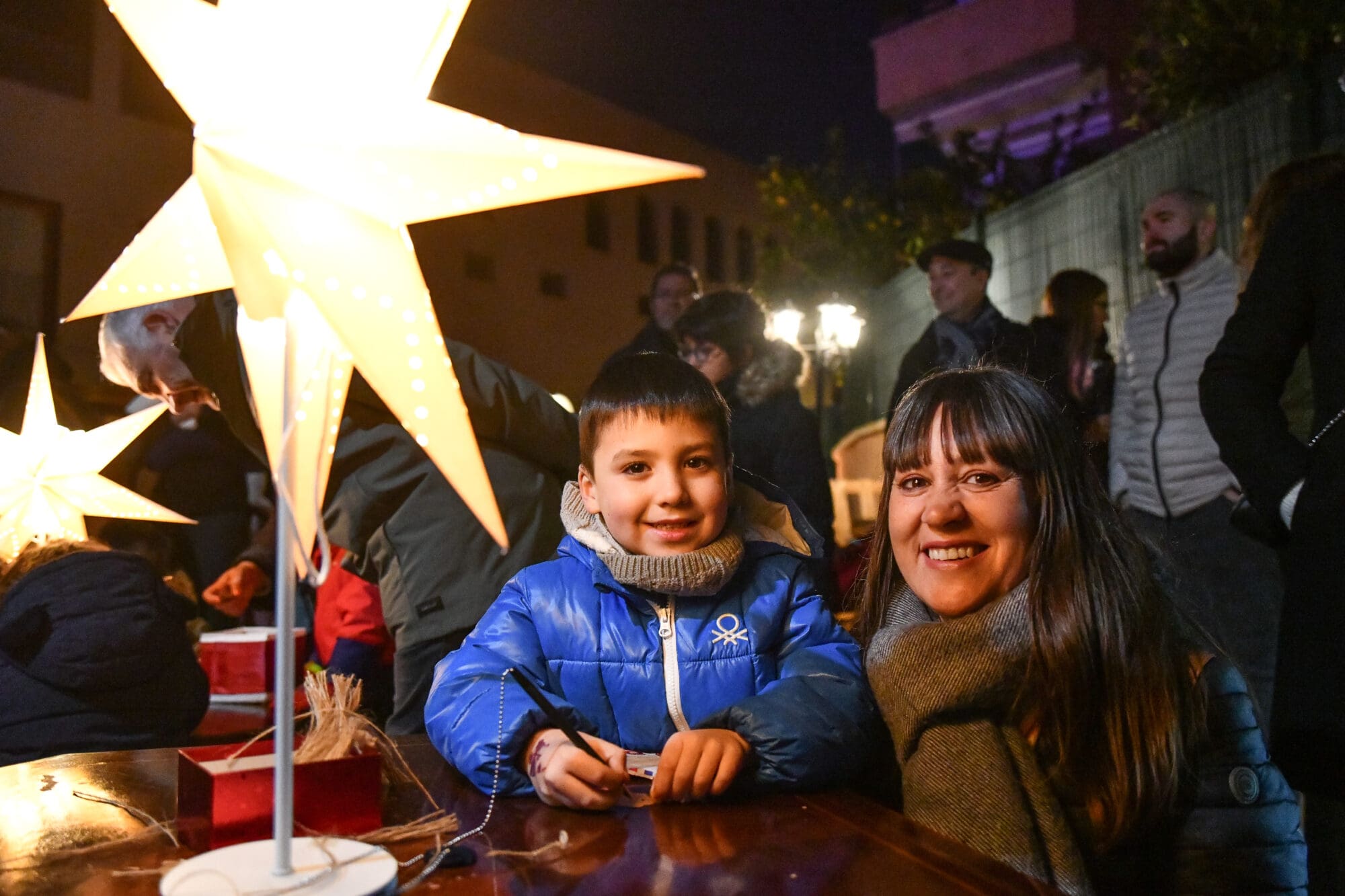 Una família, una mare i un nen, somriuen en el Campament Màgic