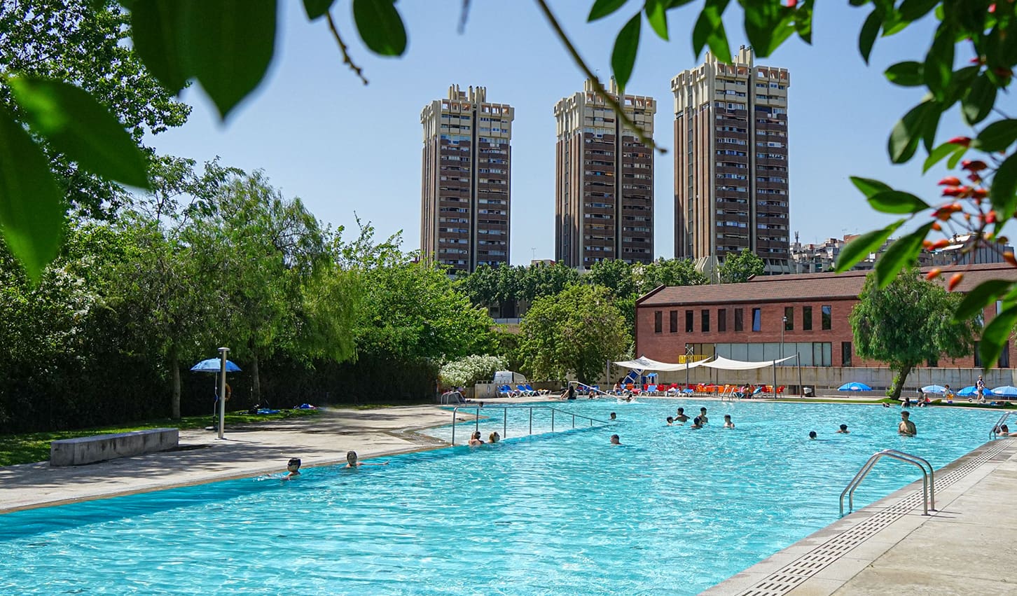 Piscina del parc dels Torrents amb els edificis Symbol de fons